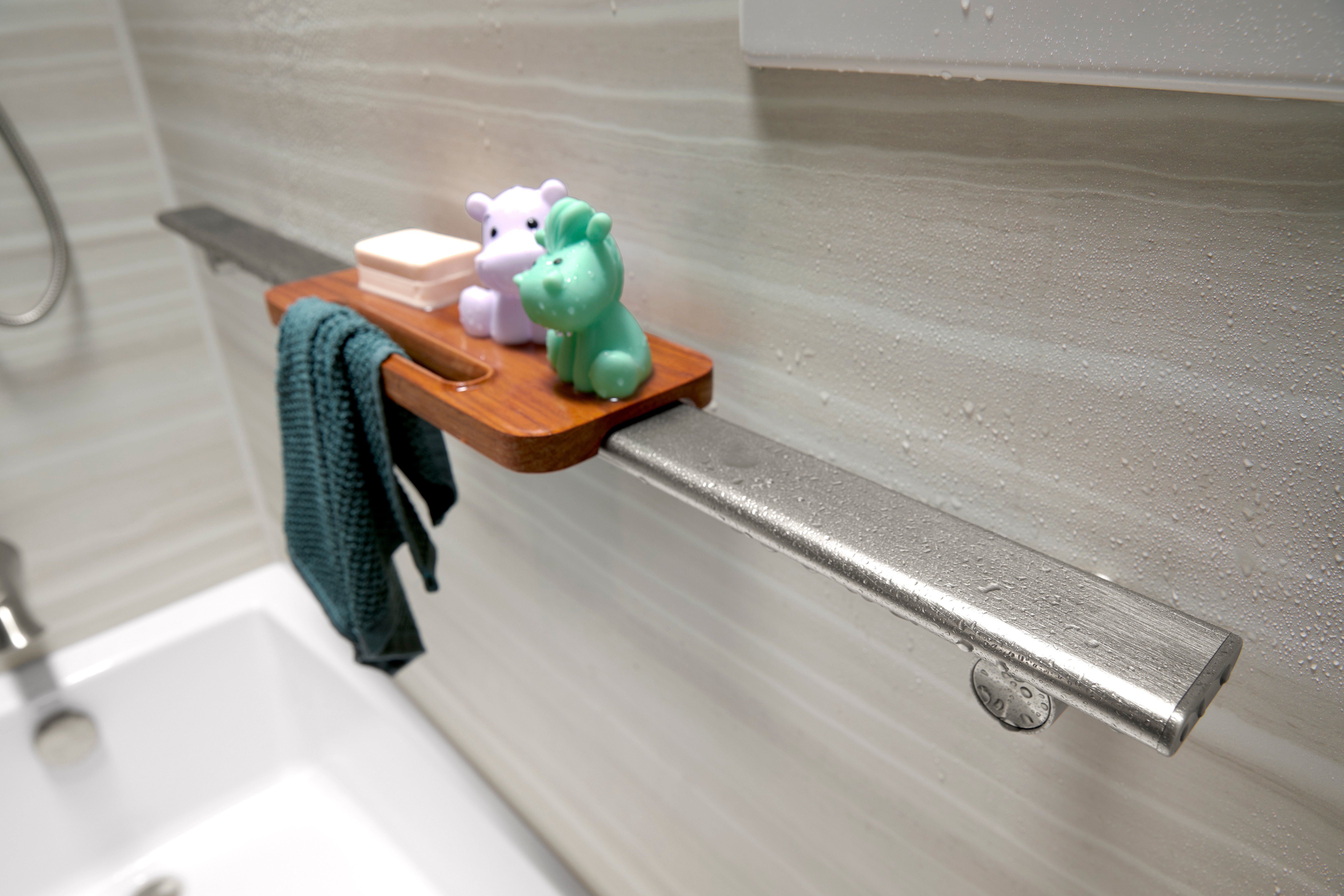 KOHLER shower bar with wooden shelf, soap, and bath toys in Denver, Colorado bathroom remodel