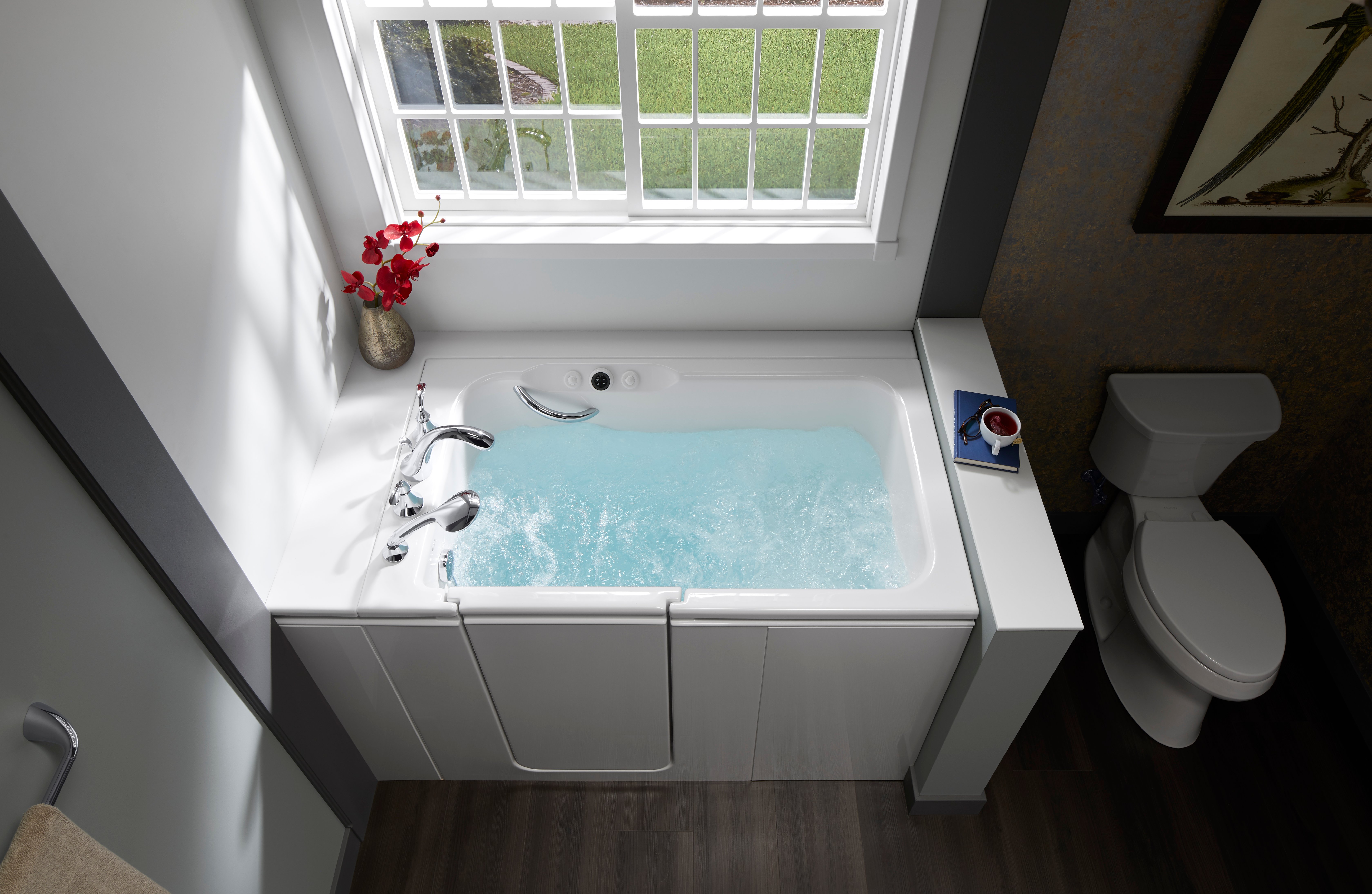 KOHLER walk-in tub with hydrotherapy jets filled with water in Denver, Colorado bathroom remodel